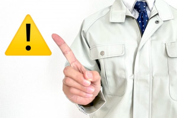 注意のマークを指指している男性