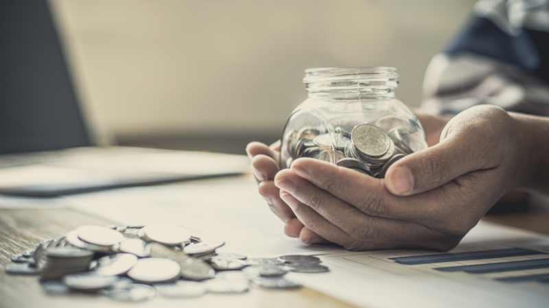 貯金箱を持つ男性